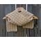 Display of the Shell Crochet Scarf pattern on a hanger in front of a wooden fence.