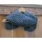 Display of the Vine Crochet Scarf on a hanger in front of a wooden fence.