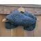 Display of the Vine Crochet Scarf on a hanger in front of a wooden fence.