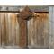 Display of the Diamond Crochet Scarf on a hanger in front of a wooden fence.