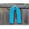 Display of the V-stitch Crochet Scarf pattern on a hanger in front of a wooden fence.