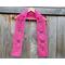 Pink Mom Crochet Scarf display on a hanger in front of a wooden fence.