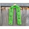 Display of the Balloon Crochet Scarf Pattern on a hanger in front of a wooden fence.