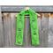 Display of the Balloon Crochet Scarf Pattern on a hanger in front of a wooden fence.