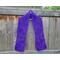 Purple scarf with hearts along the length. It is on a hanger in front of a wooden fence.