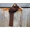Display of the Grid Crochet Scarf on a hanger in front of a wooden fence.