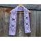 Display of the Mom Crochet Scarf on a hanger in front of a wooden fence.