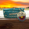This handmade glass turquoise blue bead bracelet is made on memory wire. With a charm of a cactus.