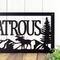 Close up of metal family name plaque with moose and mountains, in matte black powder coat.