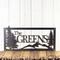 Rectangular personalized metal family name sign, with pine trees and mountain range, in silver vein powder coat.