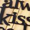 Close up of lettering on our Always Kiss Me Goodnight metal wall decor, in matte black powder coat.