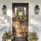 Rustic fall tobacco basket wreath on a wooden front door with berries, greenery, and a 'Fall Is In The Air' sign. Autumn porch decor.