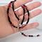 Black and red heart choker in hand.