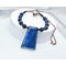 Necklace with blue lapis lazuli trapezoidal prism pendant, copper spacer beads, and round lapis lazuli beads on copper chain with hook clasp