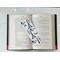laminated bookmark on top of an open book