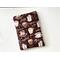 this coffee book sleeve has a checkered brown background with different coffee names and coffee