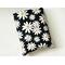 This daisy book sleeve has a black background with tiny white polka dots, and different sizes of flowers