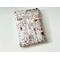 this coffee book sleeve with pocket has a light brown background with coffee cups, some donut, and different names of coffee all over the barista book holder