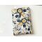 this floral book sleeve has a white background with navy, blue and gold flowers and leaves