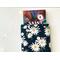 a small book peeking out of the daisy book holder