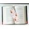 insect bookmark is lying on top of a open book