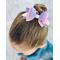 My 4 year old modeling a Lavender & pink glitter 4 layer bow. Top left corner of bow has iridescent pink embellishments.