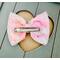 Back view of textured floral inspired soft pink, peach, blue, & yellow, hair bow, with pink sparkle shell charm on top. 