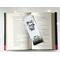 this skull book mark is on top of an open book with fairy lights above