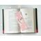 This reindeer page marker is in the middle of an open book with fairy lights above the book
