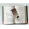 the book mark is in the middle of an open book with fairy lights above the book on a white table