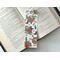 this country bookmark is on top of an open book on a white table