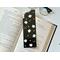 this flower bookmark is on top of an open book on a white table