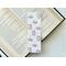 this cat unicorn bookmark has a light pink with pastel small stars in the background. There are cars and flower unicorn crowns all over