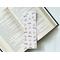 This bookish owl bookmark has a light brown background with little stars in the background. The page saver has book stacks, glasses and owls covering the bookish book mark