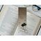 the laminated bookmark is on top of an open book with a pair of glasses on a white table