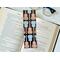 this instrument bookmark is in a real life setting with an open book and a pair of glasses