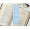 this blue coquette bookmark has blue bows, flowers and butterflies all over the page marker