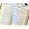 this cute bookmark has a white background with outline blue tree branches with blue flowers on them. With small blue flower all over the page holder