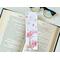 This pink floral bookmark has a gold Eiffel Tower in the bottom left corner with pink watercolor flowers blowing around the Tower. There are pink flowers, butterflies, and an airplane all over the top page holder