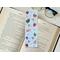 this hot chocolate bookmark has a blue background with hot cocoa, candy cane, and snowflakes all over the page saver
