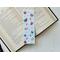 this hot chocolate bookmark is on top of an open book on a white table