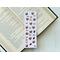 this coffee bookmark has a light purple background with medium coffee beans small and some making a heart shape. there are purple coffee cups all over the coffee bean page saver