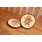 two wooden engraved coasters on coffee table with rune symbol inspired by yellowjackets television show, tv show prop