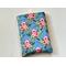 this floral book sleeve has a blue background with pink roses and green leaves all over the book holder