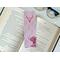 this cowgirl bookmark is on top of an open book with a pair of glasses on a white table