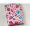 this candy book sleeve has a pink background with colorful cotton candy, lollipops, cupcakes all different candies