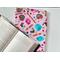 The candy book sleeve on a white table with fairy lights on the left side and an open book a little on top of the book jacket