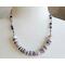necklace with 1/2" in diameter white and purple shell button style beads, smaller faceted charoite gemstones, and a stainless steel chain 