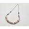 necklace with 1/2" in diameter white and purple shell button style beads, smaller faceted charoite gemstones, and a stainless steel chain 