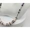 necklace with 1/2" in diameter white and purple shell button style beads, smaller faceted charoite gemstones, and a stainless steel chain 